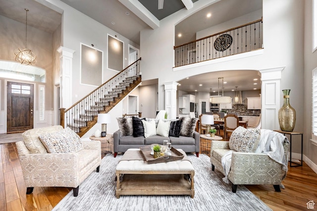 1309 W Atrium Ct W, Farmington, UT 84025 - living area with a towering ceiling, ornate columns, wood finished floors, stairs, and arched walkways