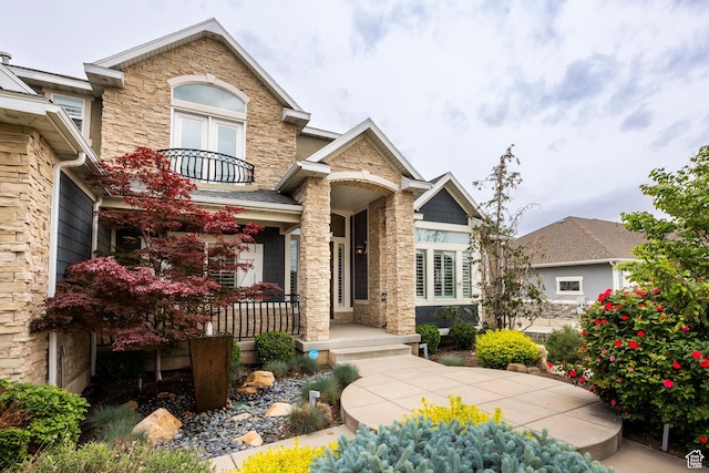 1309 W Atrium Ct W, Farmington, UT 84025 - view of front of house with stone siding, covered porch, and a balcony