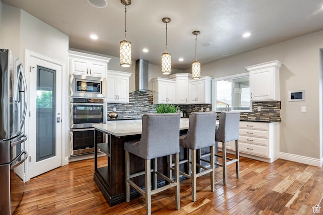1309 W Atrium Ct W, Farmington, UT 84025 - kitchen featuring wall chimney range hood, appliances with stainless steel finishes, decorative backsplash, light wood-style flooring, and recessed lighting