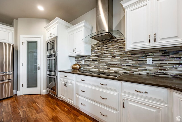 1309 W Atrium Ct W, Farmington, UT 84025 - kitchen with wall chimney range hood, stainless steel appliances, dark countertops, white cabinets, and recessed lighting