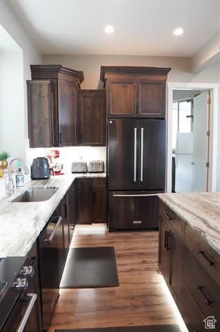 68 Hawksbeard Cir, Fish Haven, ID 83287 - kitchen with high end refrigerator, a sink, dark brown cabinets, light stone counters, and wood finished floors