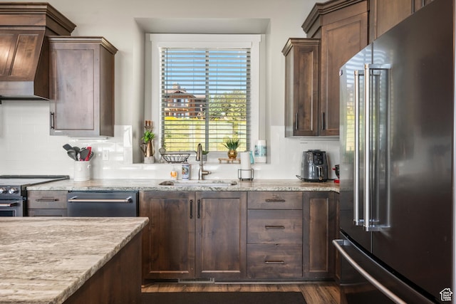 68 Hawksbeard Cir, Fish Haven, ID 83287 - kitchen featuring stainless steel appliances, custom range hood, light stone countertops, tasteful backsplash, and dark wood-type flooring