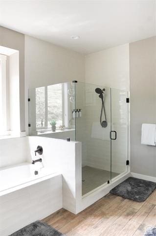 68 Hawksbeard Cir, Fish Haven, ID 83287 - full bath featuring wood finished floors, a shower stall, a garden tub, and baseboards