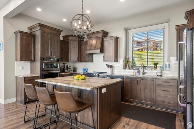 68 Hawksbeard Cir, Fish Haven, ID 83287 - kitchen with stainless steel appliances, custom exhaust hood, a center island, a chandelier, and dark brown cabinetry