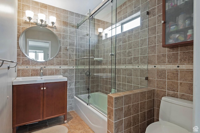 193 Coventry Ln, North Salt Lake, UT 84054 - bathroom with tile walls, tile patterned flooring, bath / shower combo with glass door, toilet, and vanity