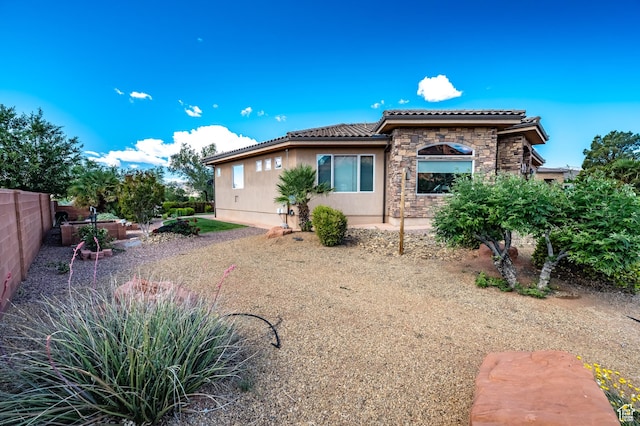373 W Meridian Dr, Ivins, UT 84738 - view of front facade featuring a tile roof, stone siding, stucco siding, and fence