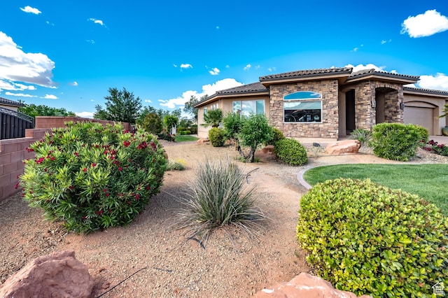 373 W Meridian Dr, Ivins, UT 84738 - view of side of home with a tiled roof, stone siding, fence, stucco siding, and an attached garage