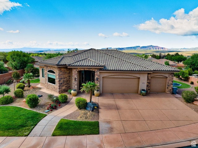 373 W Meridian Dr, Ivins, UT 84738 - mediterranean / spanish home with stucco siding, a mountain view, a garage, a tile roof, and concrete driveway