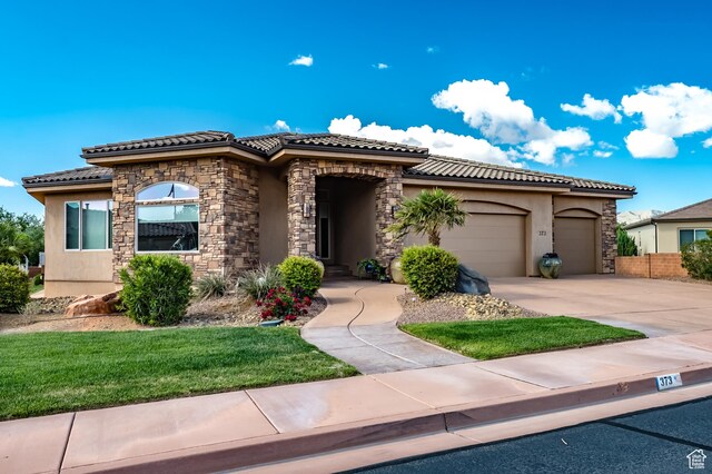 373 W Meridian Dr, Ivins, UT 84738 - mediterranean / spanish-style home featuring stucco siding, a garage, a tile roof, and driveway