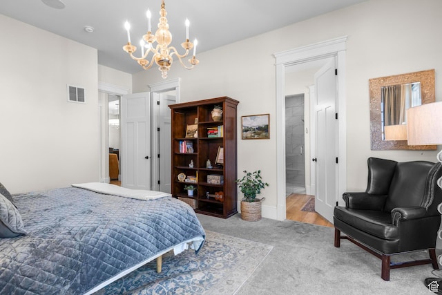 carpeted bedroom with a chandelier, ensuite bath, and baseboards
