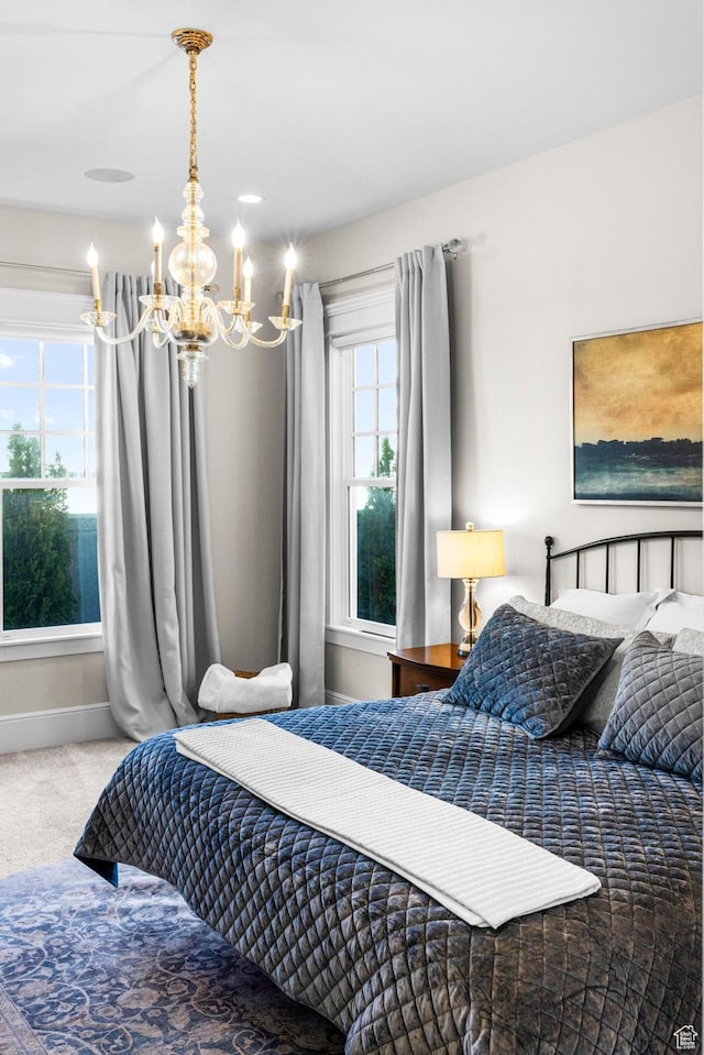 bedroom featuring a chandelier, carpet, and baseboards