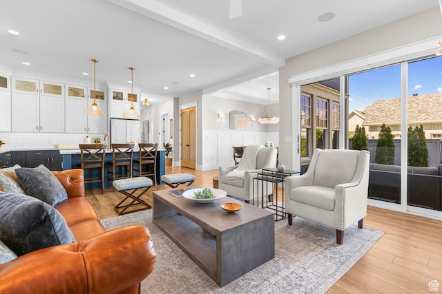 living area featuring light wood-type flooring, beamed ceiling, and recessed lighting