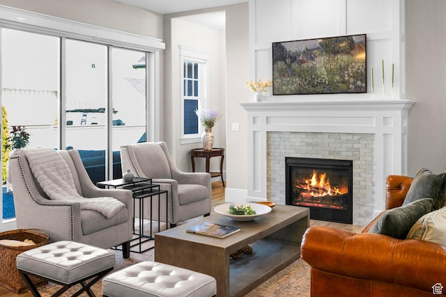 living area with a brick fireplace and wood finished floors