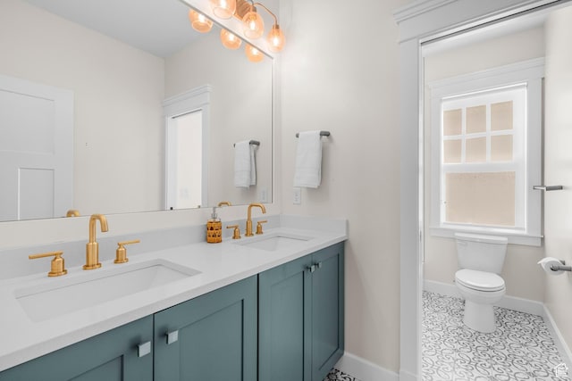full bath featuring baseboards, toilet, double vanity, and tile patterned floors