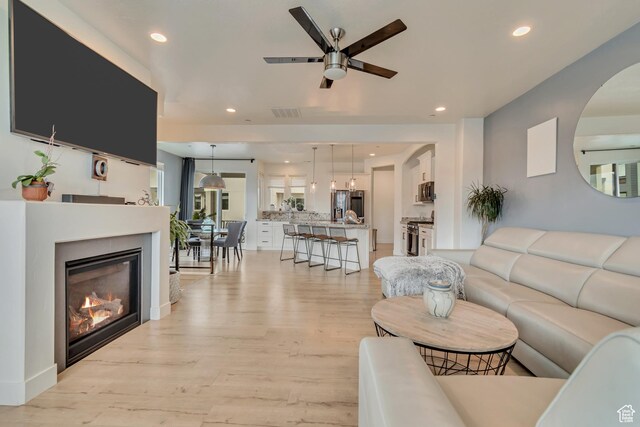 11233 S Clear Blue Dr Unit 402, South Jordan, UT 84009 - living area featuring ceiling fan, light wood finished floors, recessed lighting, and a glass covered fireplace