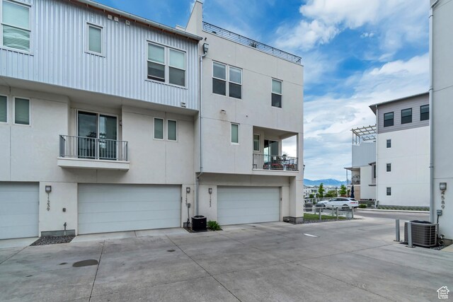 11233 S Clear Blue Dr Unit 402, South Jordan, UT 84009 - back of property with central AC unit, an attached garage, driveway, and stucco siding