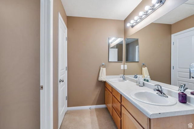 bathroom with double vanity and baseboards
