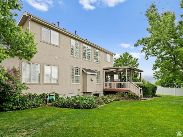 rear view of property featuring stucco siding and a wooden deck