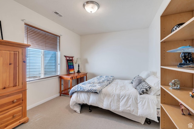 bedroom featuring light carpet and baseboards