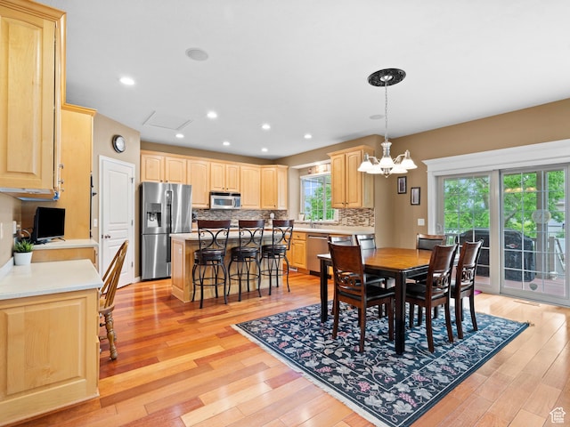 dining room with a chandelier, light wood-style floors, and recessed lighting