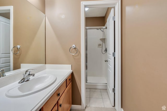 full bathroom with a shower stall, vanity, tile patterned flooring, and baseboards