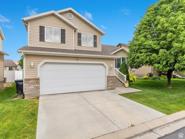 156 Crystal Bay Dr, Stansbury Park, UT 84074 - view of front of home featuring a garage, a front yard, concrete driveway, and roof with shingles