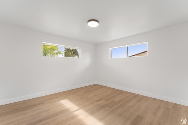 unfurnished room featuring baseboards and light wood finished floors