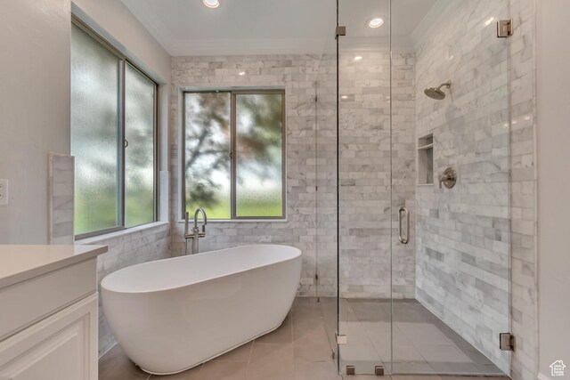 full bath featuring a freestanding bath, a shower stall, ornamental molding, vanity, and tile patterned floors