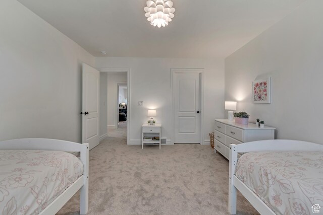 bedroom featuring light carpet and baseboards