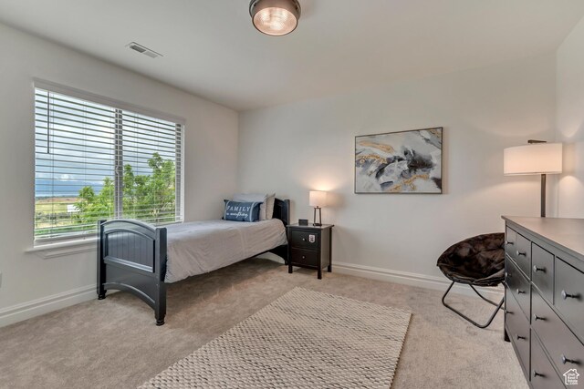 bedroom with light colored carpet and baseboards