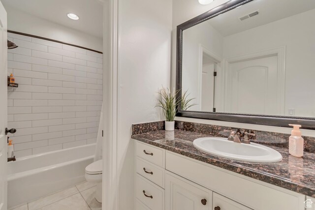 bathroom with toilet, tile patterned flooring, vanity, and shower / bath combo