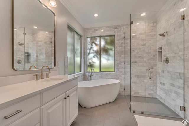 bathroom with ornamental molding, vanity, a shower stall, a freestanding bath, and tile patterned flooring