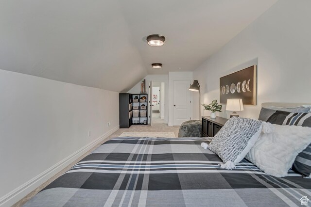 bedroom with vaulted ceiling, baseboards, and carpet floors