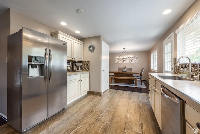 1256 E Darby Cir S, Murray, UT 84117 - kitchen with stainless steel appliances, a sink, decorative backsplash, a chandelier, and light countertops