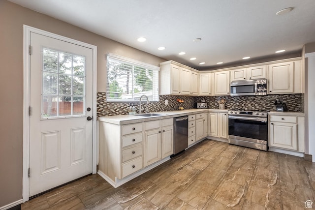 1256 E Darby Cir S, Murray, UT 84117 - kitchen with appliances with stainless steel finishes, a sink, light countertops, backsplash, and recessed lighting