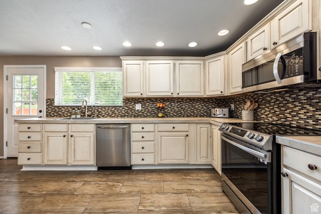 1256 E Darby Cir S, Murray, UT 84117 - kitchen with appliances with stainless steel finishes, a sink, recessed lighting, light countertops, and decorative backsplash
