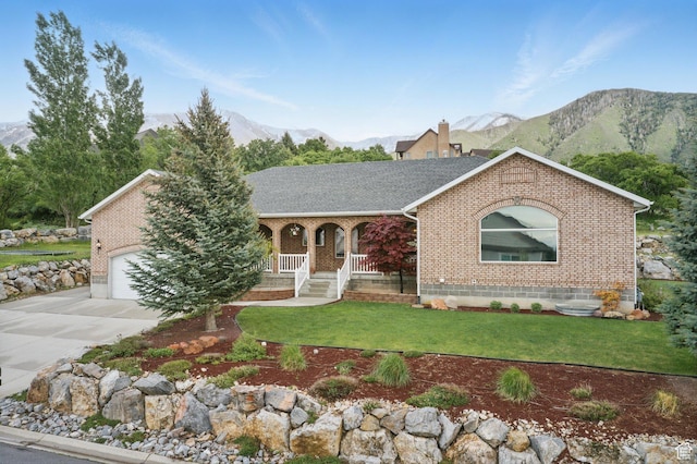 view of front of property featuring brick siding, a mountain view, a porch, and driveway