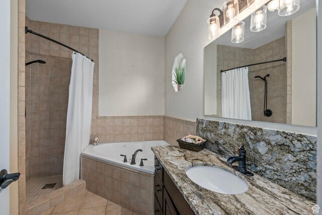 bathroom with a shower stall, a garden tub, tile patterned flooring, and vanity