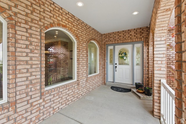 property entrance featuring brick siding and a porch