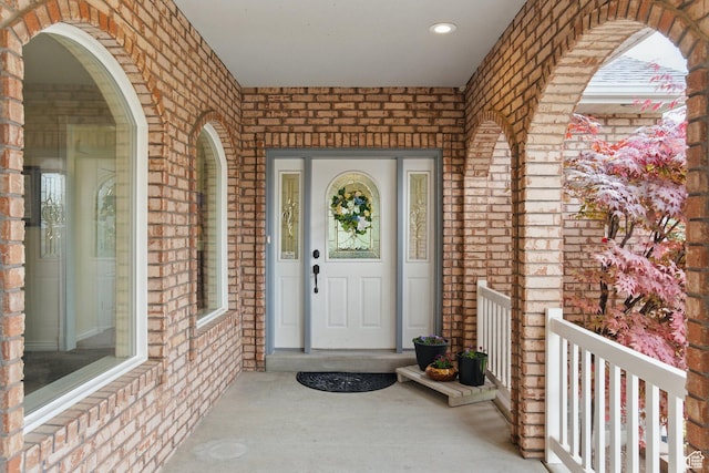property entrance with brick siding and a porch