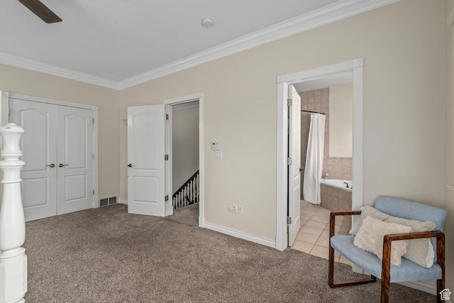 bedroom featuring ornamental molding, carpet, baseboards, ensuite bath, and a closet