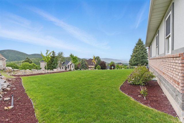 view of green lawn featuring a mountain view