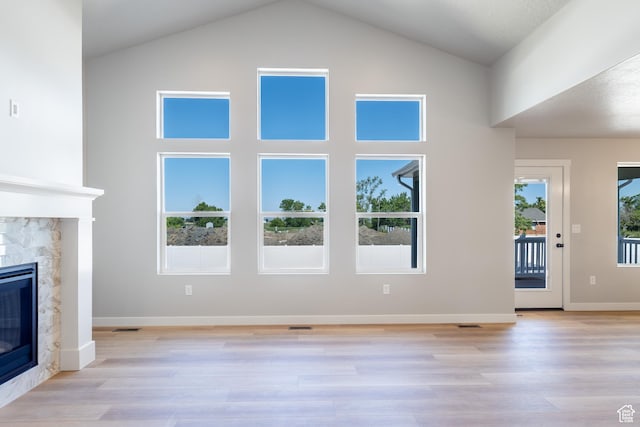 709 S 3575 W Unit 147, West Weber, UT 84401 - unfurnished living room featuring a stone fireplace, high vaulted ceiling, and light wood-type flooring