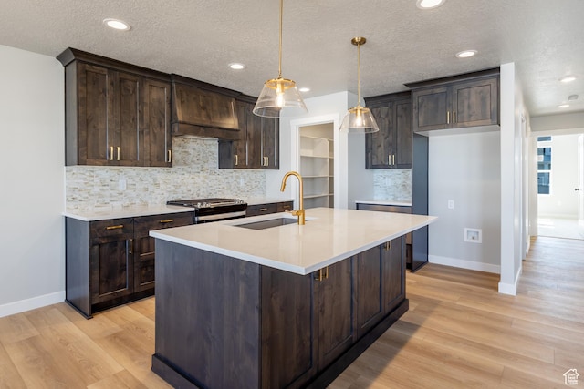 709 S 3575 W Unit 147, West Weber, UT 84401 - kitchen with range with gas stovetop, dark brown cabinetry, light wood finished floors, decorative backsplash, and a textured ceiling