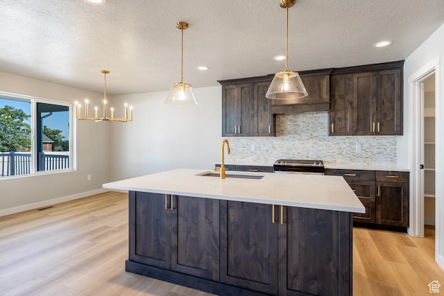 709 S 3575 W Unit 147, West Weber, UT 84401 - kitchen with black electric range oven, light wood finished floors, backsplash, dark brown cabinetry, and a textured ceiling