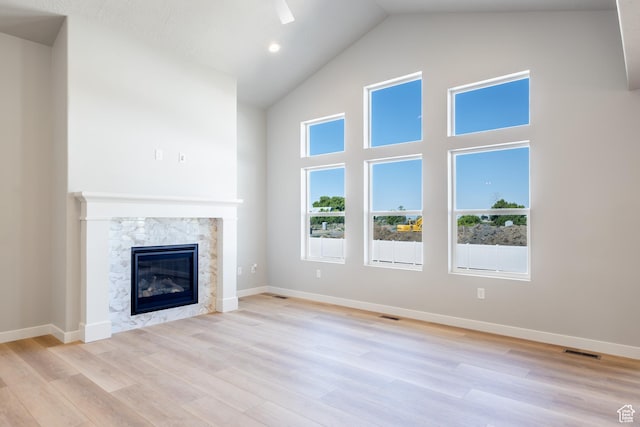 709 S 3575 W Unit 147, West Weber, UT 84401 - unfurnished living room featuring high vaulted ceiling, a premium fireplace, and light wood finished floors