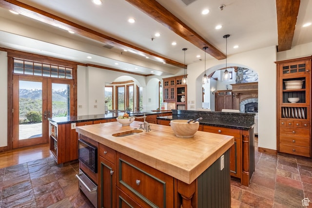 2000 W Red Hawk Trl, Park City, UT 84098 - kitchen with a spacious island, beamed ceiling, stone tile floors, built in microwave, and french doors