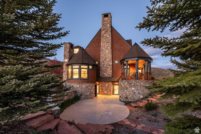 2000 W Red Hawk Trl, Park City, UT 84098 - view of front of property featuring stone siding, a chimney, a balcony, a patio, and a shingled roof