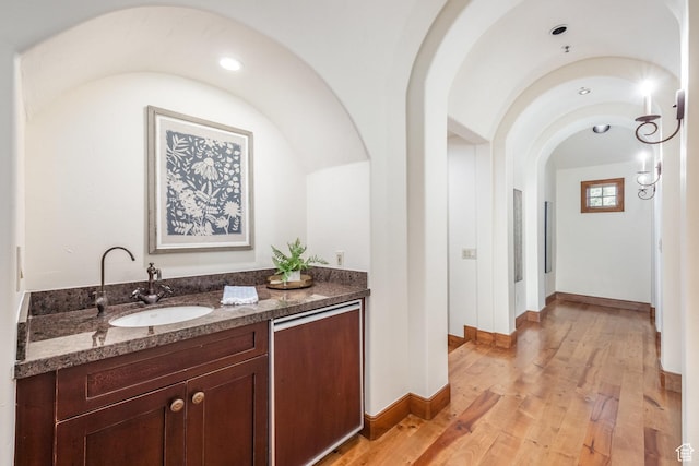 2000 W Red Hawk Trl, Park City, UT 84098 - bar with a sink, arched walkways, light wood finished floors, and baseboards
