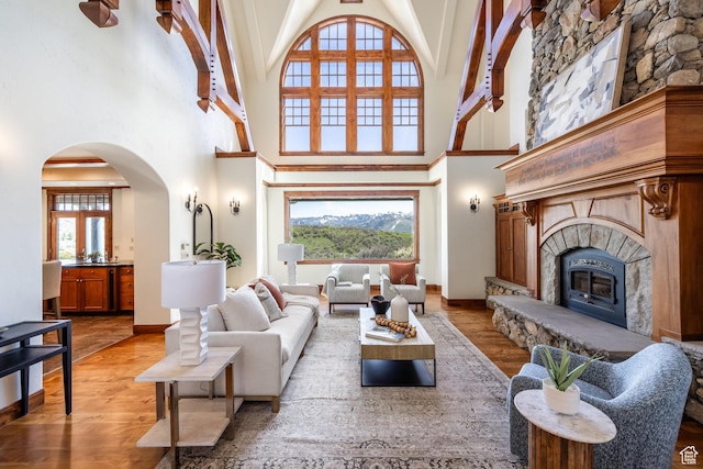 2000 W Red Hawk Trl, Park City, UT 84098 - living room with a towering ceiling, light wood-type flooring, arched walkways, a glass covered fireplace, and baseboards